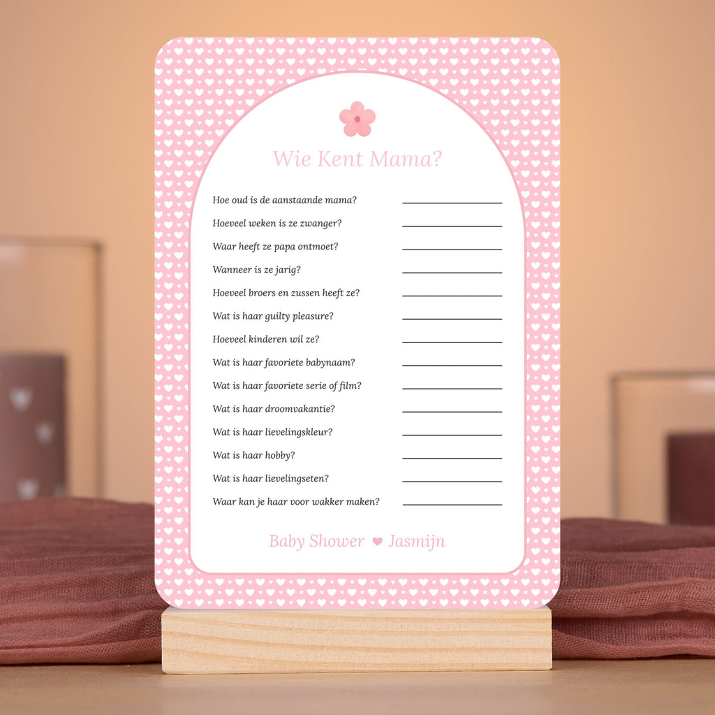 Wie kent Mama? kaart met witte hartjes op roze achtergrond en bloemaccent – sfeervolle setting met babyshower decoratie – Studio Miron